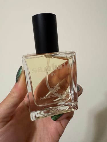 Customer holding the square, etched bottle of Samhain fragrance.
