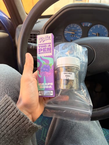 Customer holding the purple packaging for the ROLLZ THCA Vape, Grape Soda flavor, inside a car.