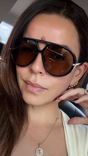 Cliente usando os Óculos Veneza com armação preta grande e lentes em degradê marrom.