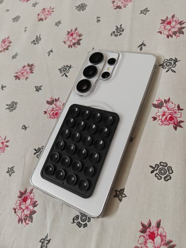 Reviewer's white phone in the Anti Yellow Clear Case, with a black suction pod attached to the back.