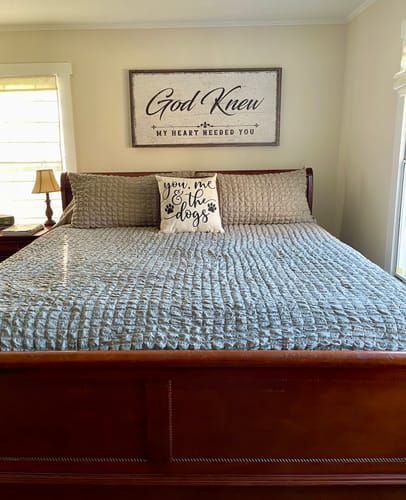 Customer's God Knew Sign hanging on the wall above their bed in a cozy bedroom.