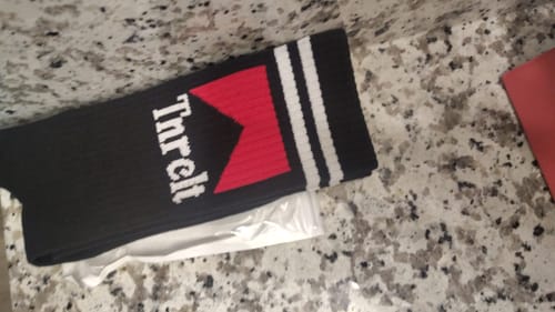 Customer's black SMOKE' EM SOCKS with a red graphic and white stripes on a countertop.
