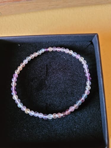 Avis d'un client : le bracelet en Fluorine Arc-en-ciel aux perles facettées et multicolores, dans son écrin noir.