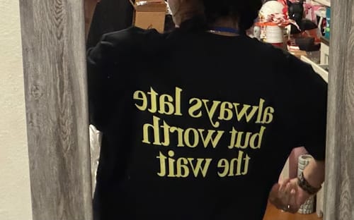 Reviewer's mirror selfie showing the back of the black Worth The Wait Tee.