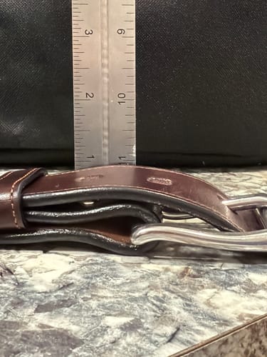 Customer measuring The Canyon belt's buckle with a ruler, showing it sticks out by about one inch.