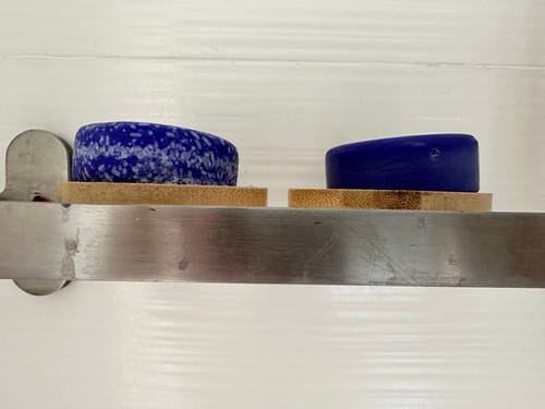 Customer's speckled Violet Toning Shampoo Bar and a solid conditioner bar on two bamboo holders.