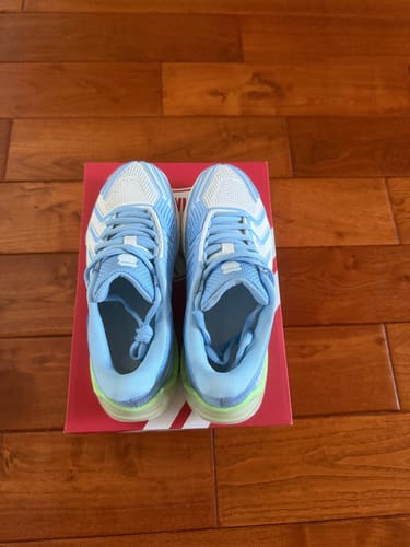 Customer's new ULTRASHOT 4 shoes in blue and white, with green soles, seen from above on the shoebox.