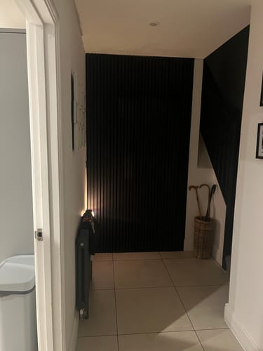 Customer's black acoustic slatted wall panels installed as a feature wall in a hallway.