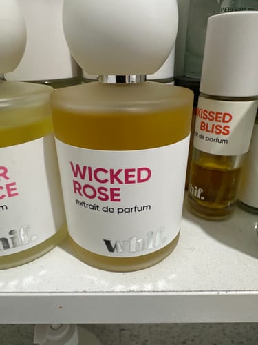 Customer's Wicked Rose perfume in a frosted bottle sitting on a shelf with other fragrances.