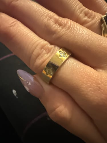 Close-up of a customer's hand wearing the 18K gold-plated Eloise Birthstone Ring with its clover settings.