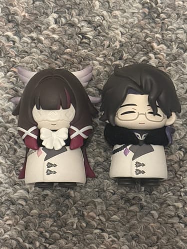 Customer displays two cute Fatui Harbingers chibi figures from the blind box series.