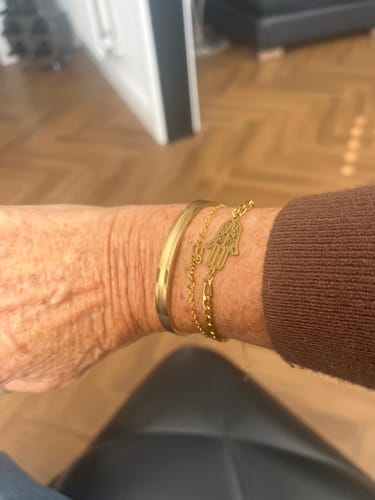 Customer showing the Be Brave Bangle on their wrist, worn in a stack with other bracelets.