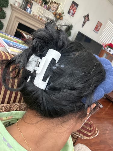 Reviewer with their dark hair in a messy updo, held in place by a white cloud clip.