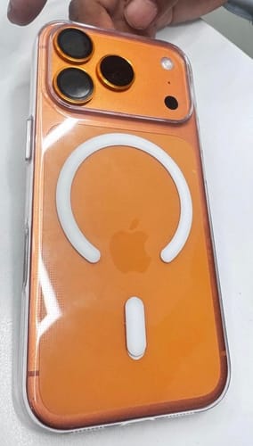 Customer holding an orange phone inside the clear Anti Yellow Magsafe Case, showing the back and MagSafe feature.
