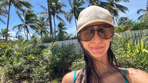 Cliente tira uma selfie ao ar livre usando os estilosos Óculos Veneza e um boné.