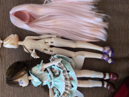 Reviewer's Momotale accessories, including a nude doll body, a pink wig, and a dressed doll, laid out side-by-side.