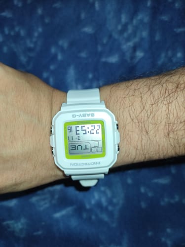 Un reseñador lleva puesto en la muñeca el reloj Casio Baby-G blanco, que queda bien en un brazo delgado.