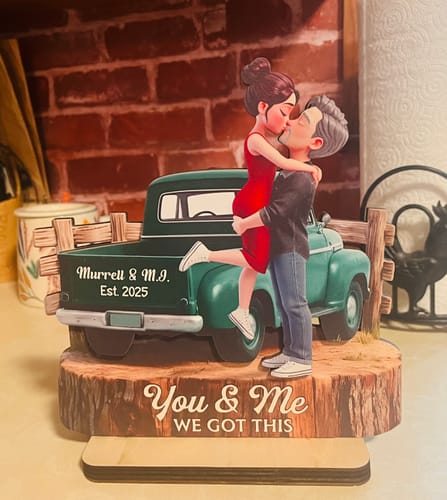 Customer's personalized 2-layered wooden plaque showing a couple kissing by a green truck, on a base reading 'You & Me WE GOT THIS'.
