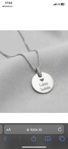 Customer's close-up of a silver Stellar Names Necklace with a round pendant engraved with two names and a heart.