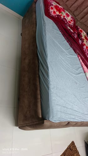 Customer's Flo Mattress Ortho on a bed frame, with a light blue fitted sheet covering the top.