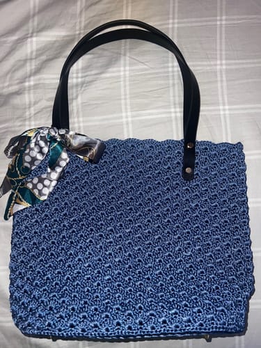 Reviewer's completed blue Aveline crochet Shoulder Bag, with black straps and a patterned scarf tied to the handle.