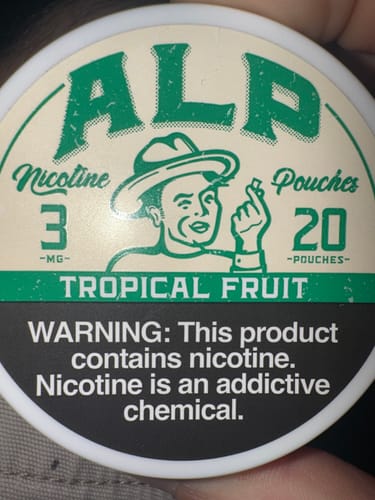 A customer's close-up of the ALP Tropical Fruit Nicotine Pouches can, showing the green and cream label.