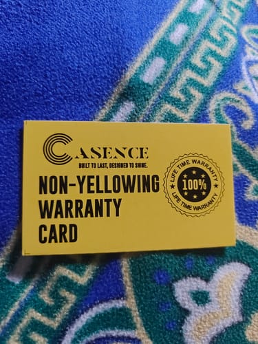 Customer shows the yellow Casence Non-Yellowing Warranty Card on a blue patterned surface.