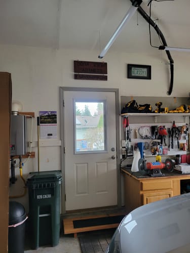 Customer's Raise & Lower Blinds Glass Kit installed on a white door in a garage, with the blinds fully raised.