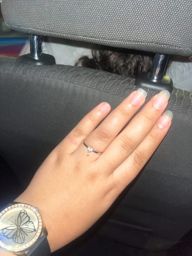 Customer's hand wearing the Silver Passionate Love Ring, showing its delicate band and small heart-shaped zircon.