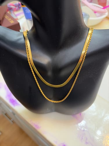 Customer's shiny gold Alexandra Layered Necklace displayed on a black mannequin bust.