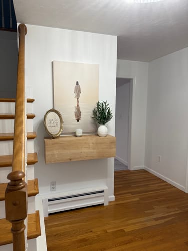 Customer's Jesus Walking on Water wall art hanging on a white wall above a wooden shelf in an entryway.