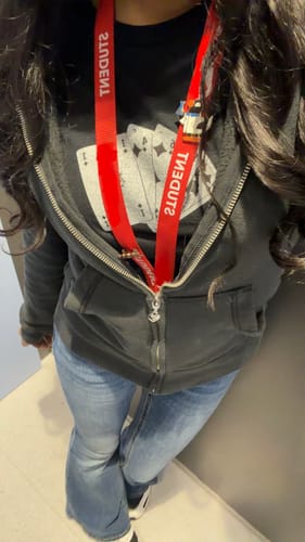 Reviewer wearing the black counting cards baby tee layered under a dark zip-up hoodie.