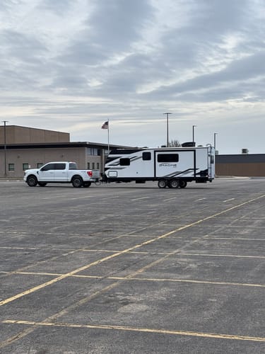 Customer's Ford F-150 with HD Kit installed, showing a level ride while towing a large travel trailer.