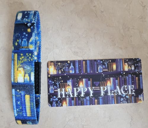 Customer's blue Happy Place Bracelet and matching card, featuring a magical bookshelf design with glowing candles.