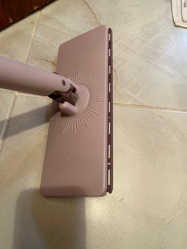 Müşterinin pembe renkli Snowly FlexiClamp Pro paspasının başlığının fayans zemin üzerindeki yakın çekim görüntüsü.