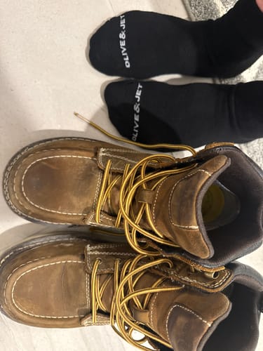 Customer's black Quarter Socks laid out next to a pair of brown work boots.