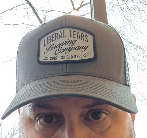 Close-up of a reviewer wearing the gray Liberal Tears Brewing Company Woven Patch Hat.