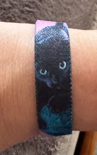 Customer wearing the I Need Dis Cat Bracelet, showing the design of a black cat with a teal ball of yarn.