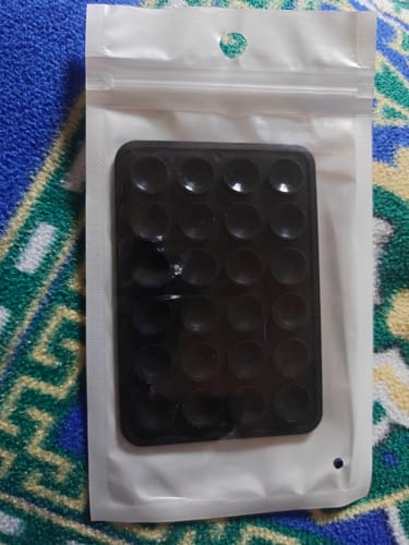 Customer's black StickyPod shown inside its white packaging.