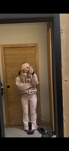 Reviewer taking a mirror selfie wearing the pink insulated snow jacket and matching pants.