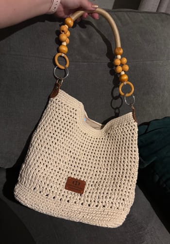 Customer holding their completed cream CrochetPark™ Sunny Beach Tote with its distinct beaded handle.