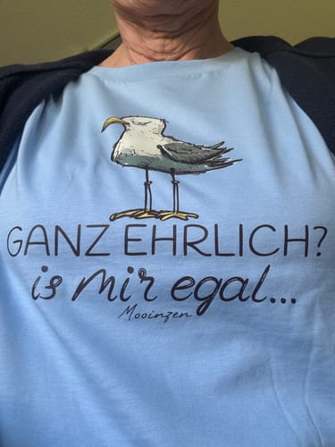 Eine Rezensentin trägt das hellblaue Premium Bio T-Shirt mit dem Aufdruck 'Ganz ehrlich? is mir egal...'.