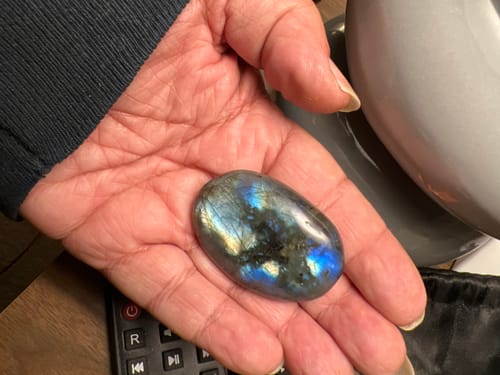 Customer holding a polished Labradorite crystal, highlighting its gorgeous fire.