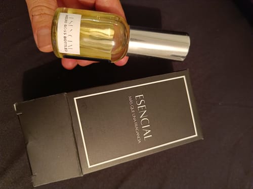 Cliente sosteniendo el frasco del perfume H030 Inspirado en Boss Bottled, junto a su caja negra.