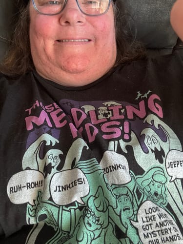 Close-up of a reviewer wearing the black 'Those Meddling Kids' Scooby-Doo t-shirt with its detailed graphic.