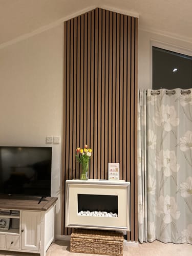 Customer's slat wall panel installed on a tall living room wall with an angled ceiling.