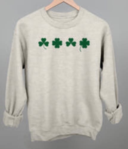 Customer's off-white Clover Illustrations sweatshirt on a hanger, showing four green clovers across the chest.