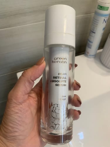 Avis d'un client : main tenant le flacon de sérum RETINAL ABSOLUTE 0.03.