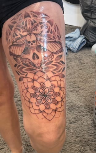 Reviewer shows a large, fresh thigh tattoo after using the Painless Tattoo Numbing Cream.