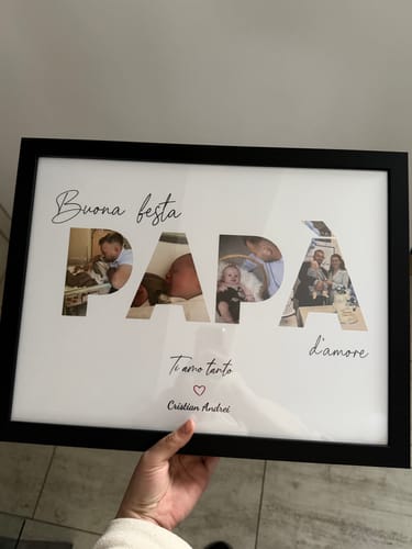 Un recensore tiene in mano il poster personalizzato per la festa del papà, con le foto all'interno della parola "PAPÀ".